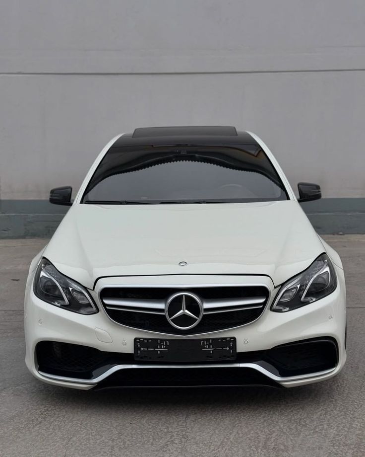 White Mercedes-Benz E-Class W212 facelift sedan in the mountains